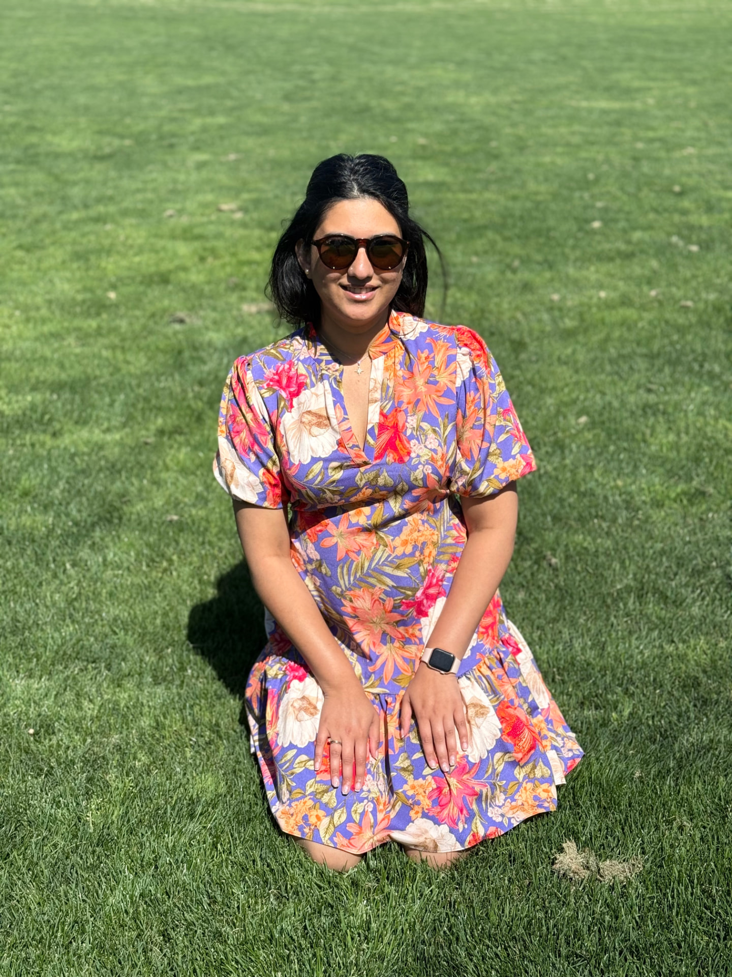 Ranjani, founder of Katha Clicks, kneeling on the grass in a floral dress