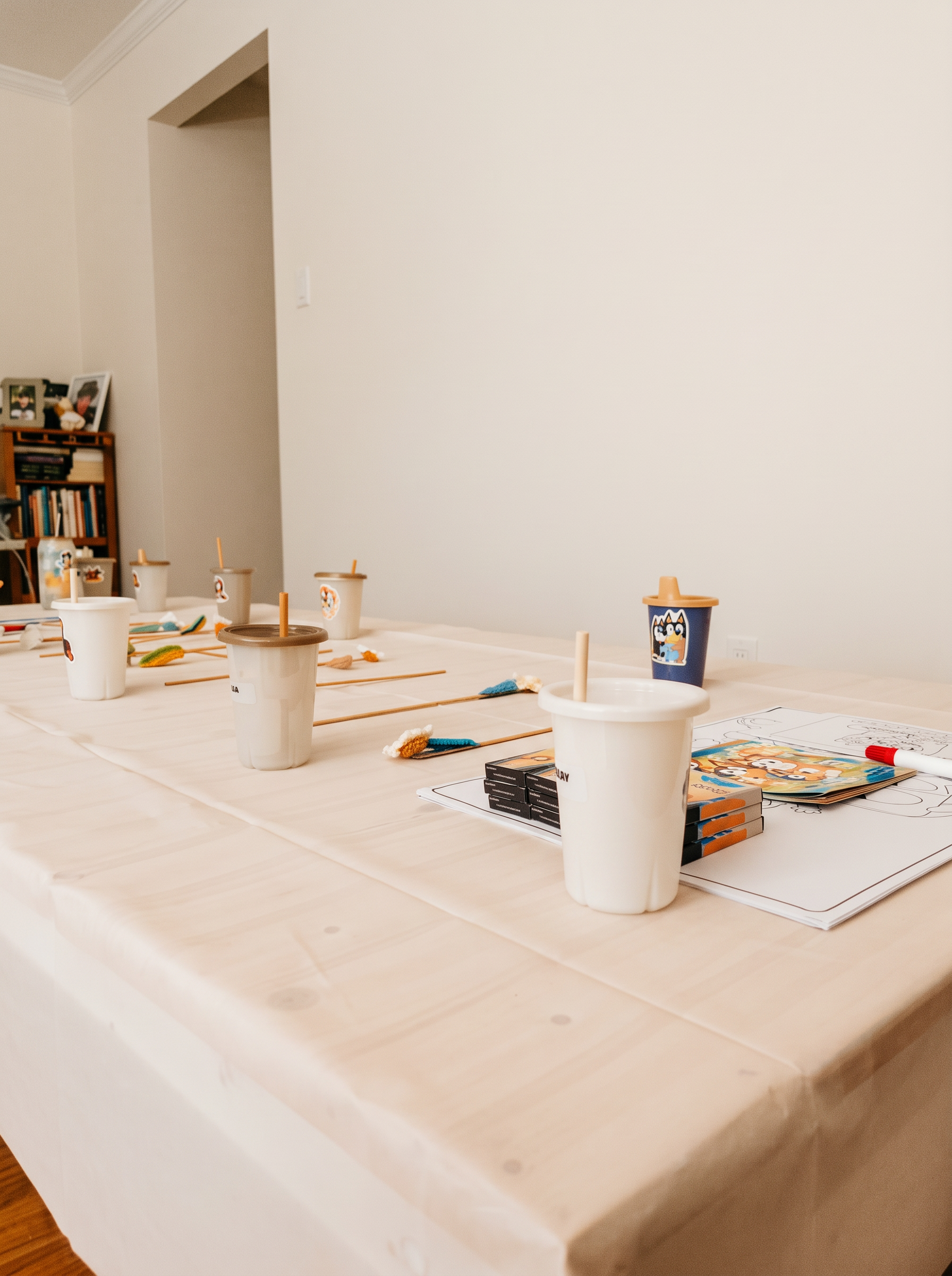 A kids' celebration table set with cups, paintbrushes and activity sheets