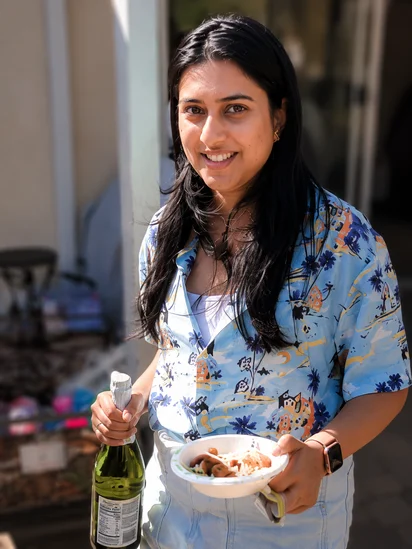 Ranjani hosting in the backyard, holding a bowl of food