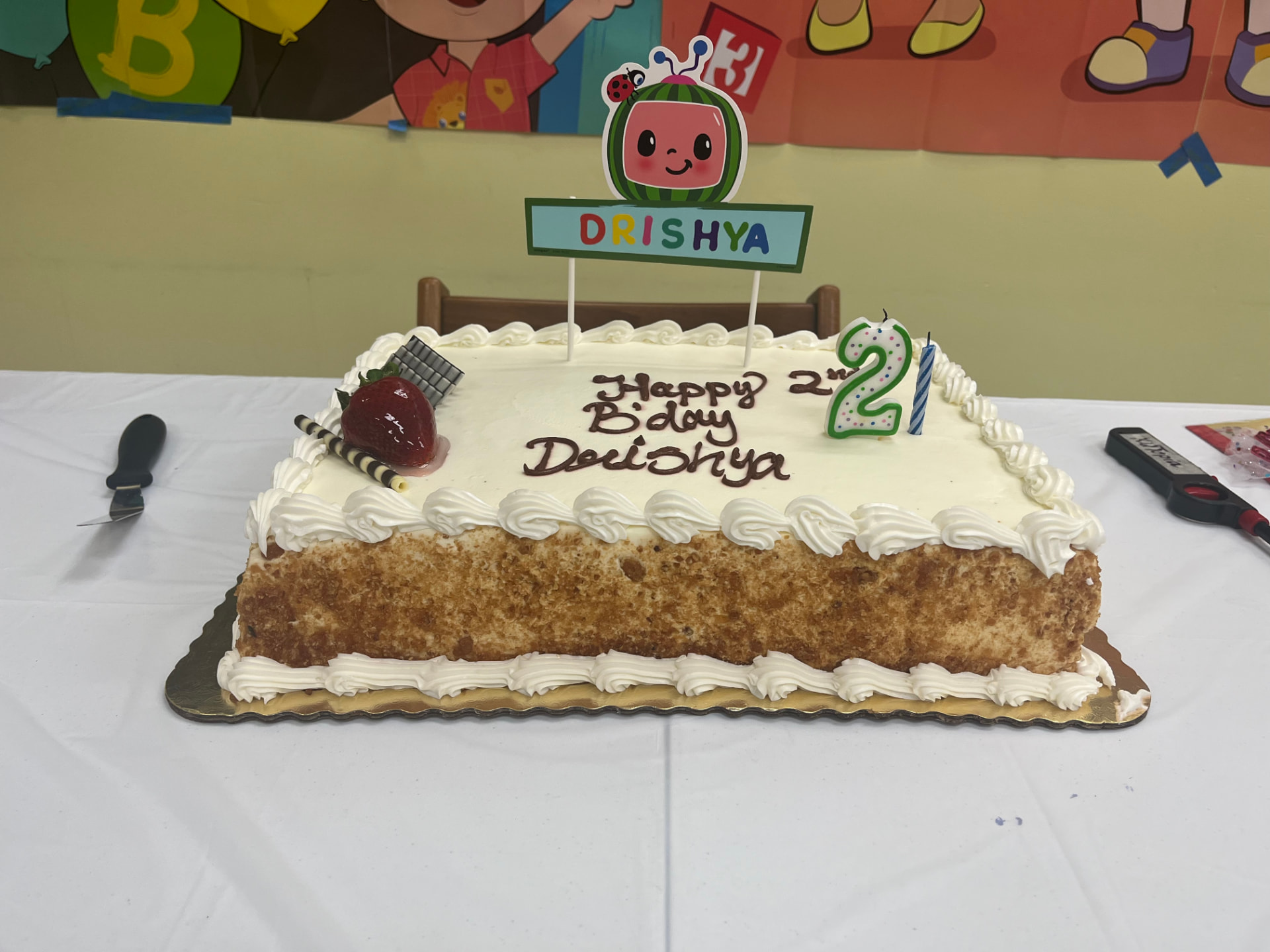 A hand-decorated birthday cake with a piped message and a single candle on a kitchen counter